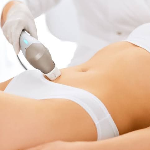 A gloved professional performs a laser hair removal treatment on a woman's lower abdomen.